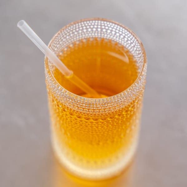 Close-up of a glass of iced tea with a straw, condensation visible on the glass.