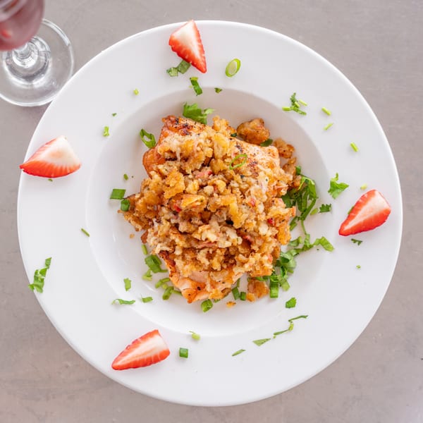 Uptown Joes New York Diner's breakfast dish with crispy topping, green herbs, and strawberry slices.