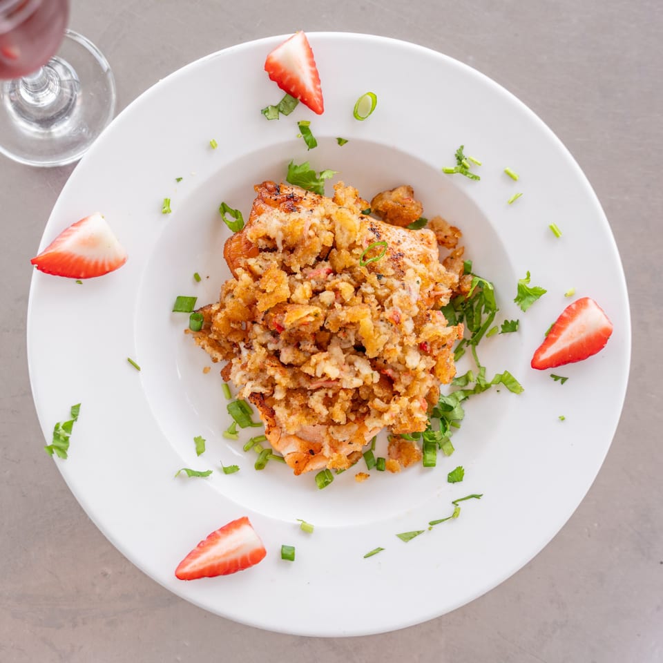 Uptown Joes New York Diner's breakfast dish with crispy topping, green herbs, and strawberry slices.