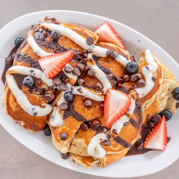 Uptown Joes New York Diner's chocolate chip pancakes with chocolate drizzle, cream, strawberries, and blueberries.