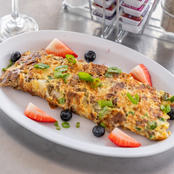 Uptown Joes New York Diner's breakfast omelet with strawberries, blueberries, and green onions.